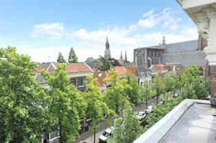 Uitzicht vanaf het dakterras over Delft met de Oude Kerk